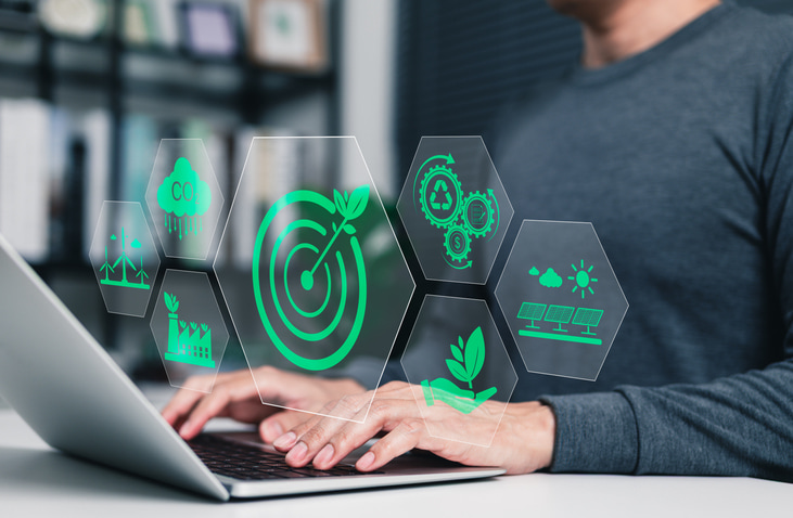 zero waste initiative concept image. Man typing on computer with green initiative icons overlay